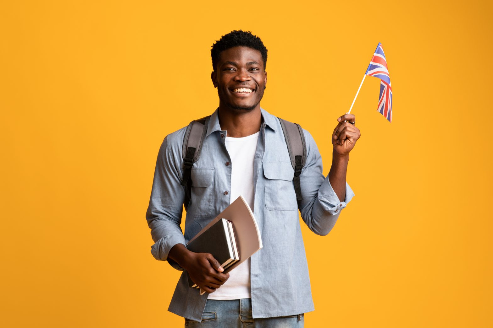Happy black guy student showing flag of UK