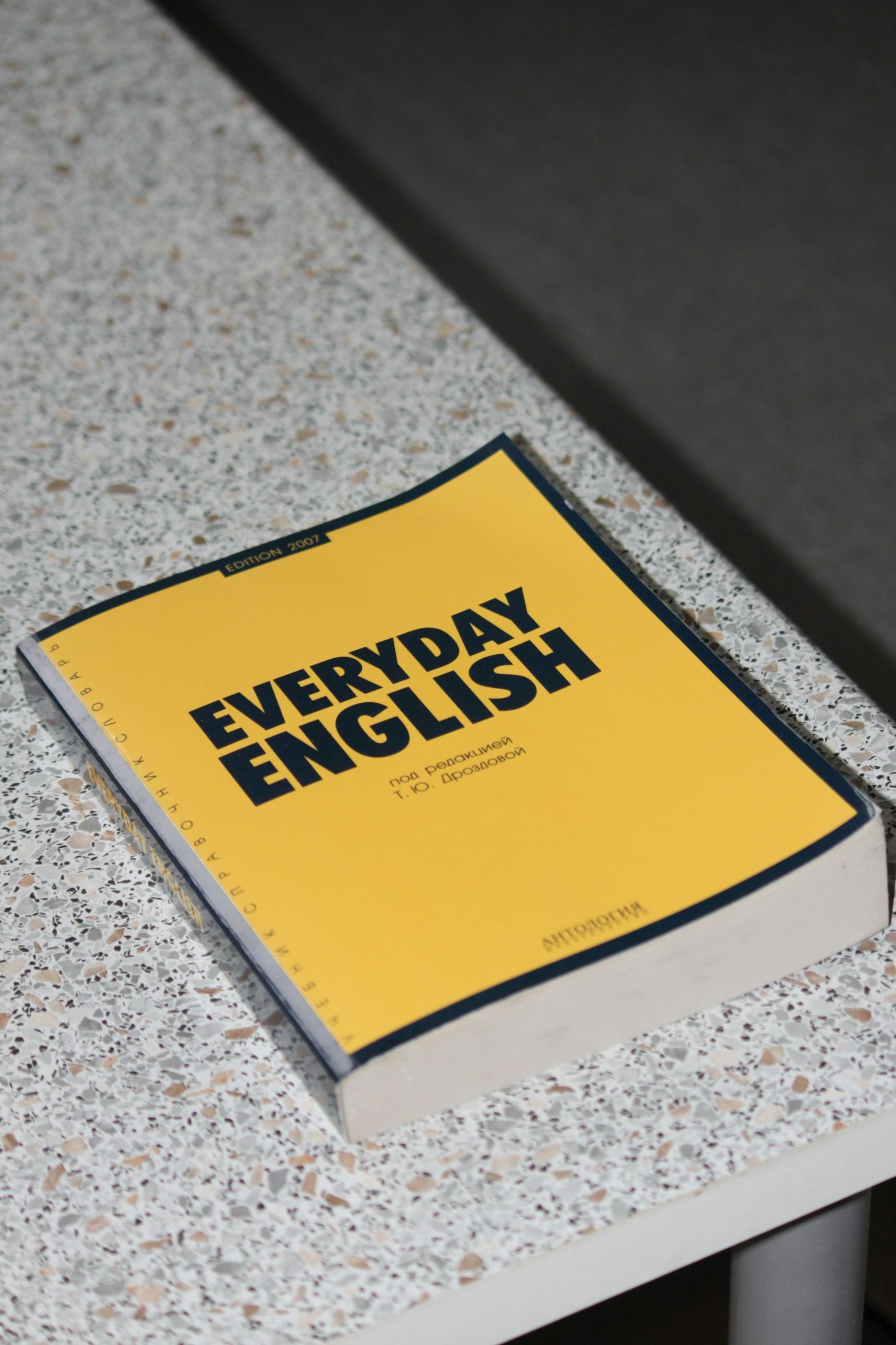 Yellow textbook on desk with the title Everyday English
