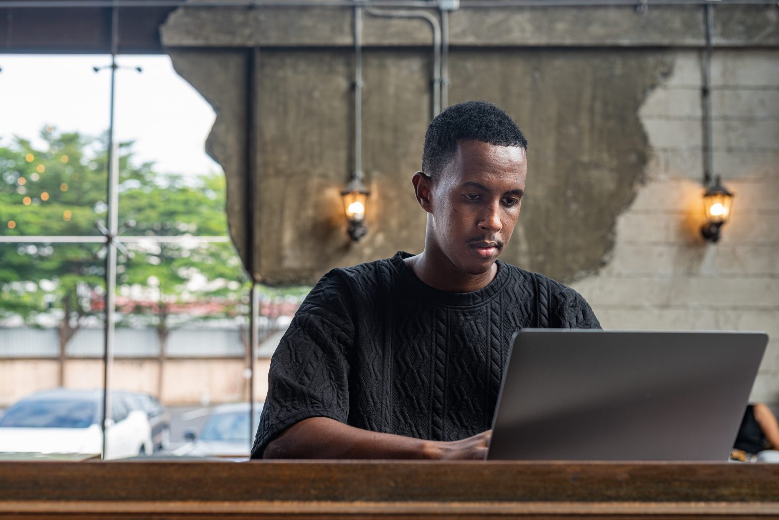 Portrait of black man sitting and using laptop computer indoors
