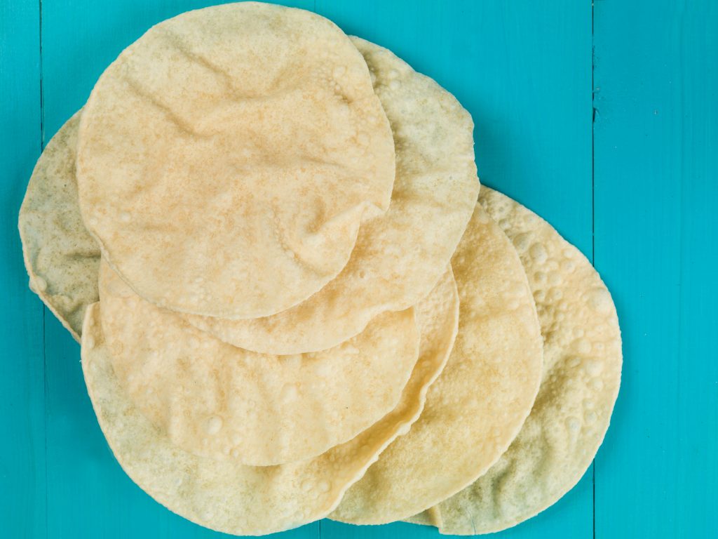 Indian Style Crispy Thin Poppadoms Against a Blue Background