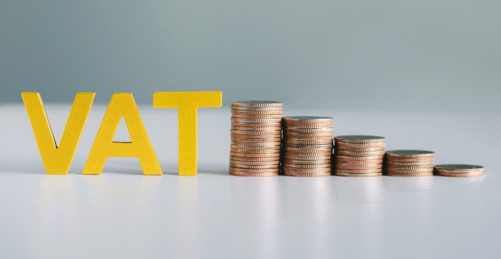 Word vat and stacked coins on white table