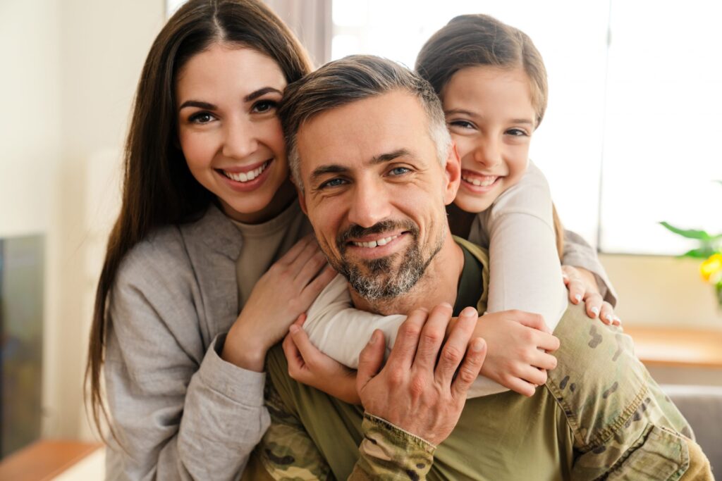Happy man smiling and hugging his family indoors