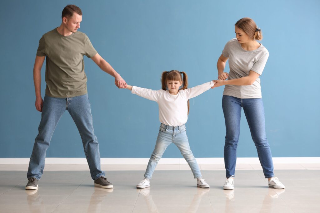 Divorced parents arguing about child custody against blue wall