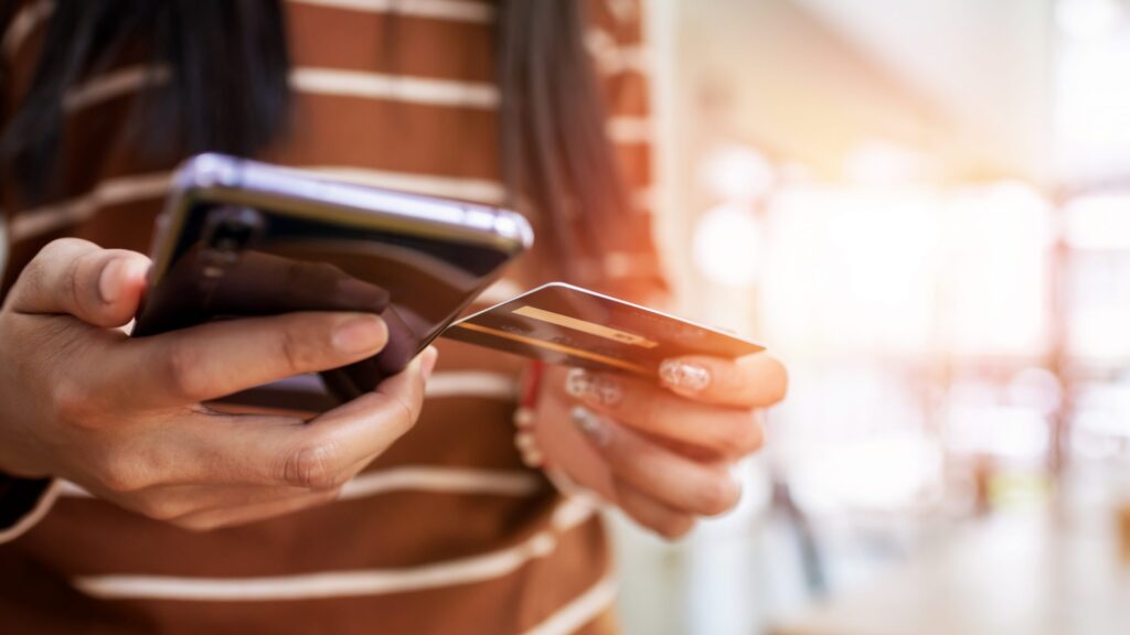 Close up young woman hands holding credit card and using mobile smart phone. Asian people.