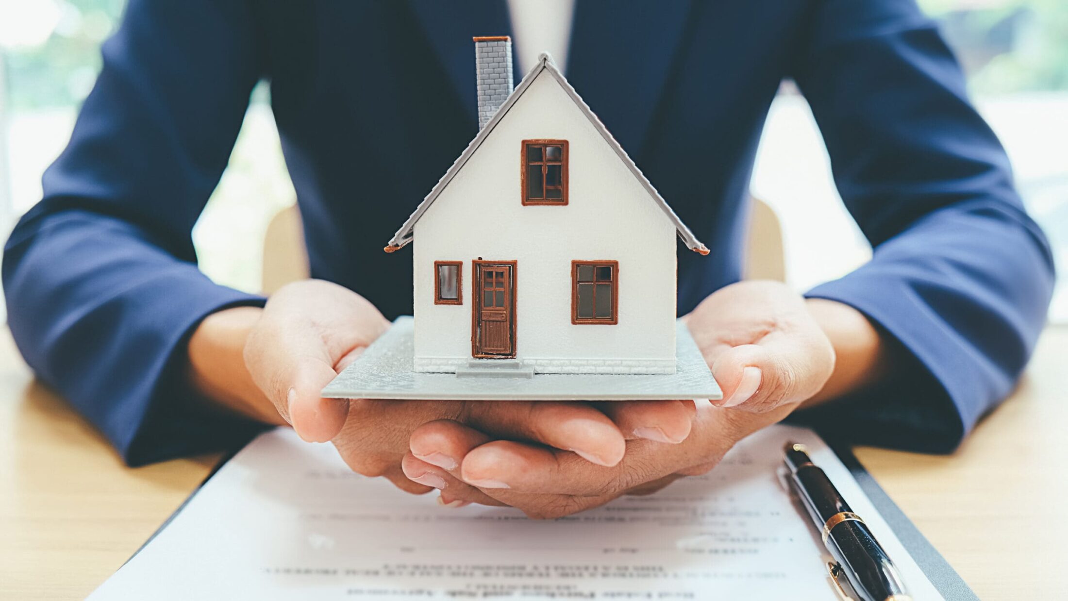 House model with real estate agent and customer discussing for contract to buy house insurance or loan real estate background