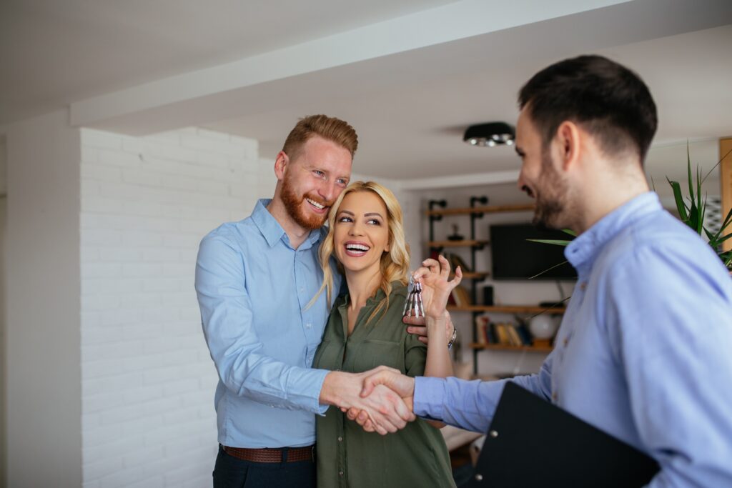 Couple shaking hands with estate agent
