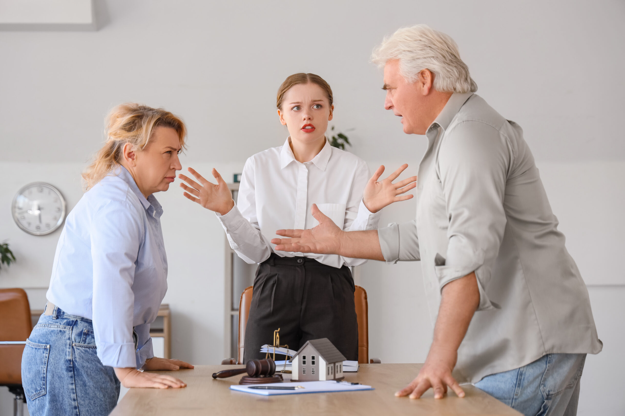 Angry mature couple visiting divorce lawyer in office