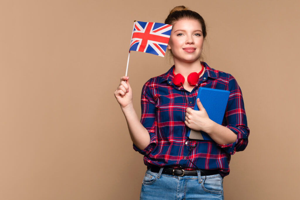 girl holds small UK flag and notebook
