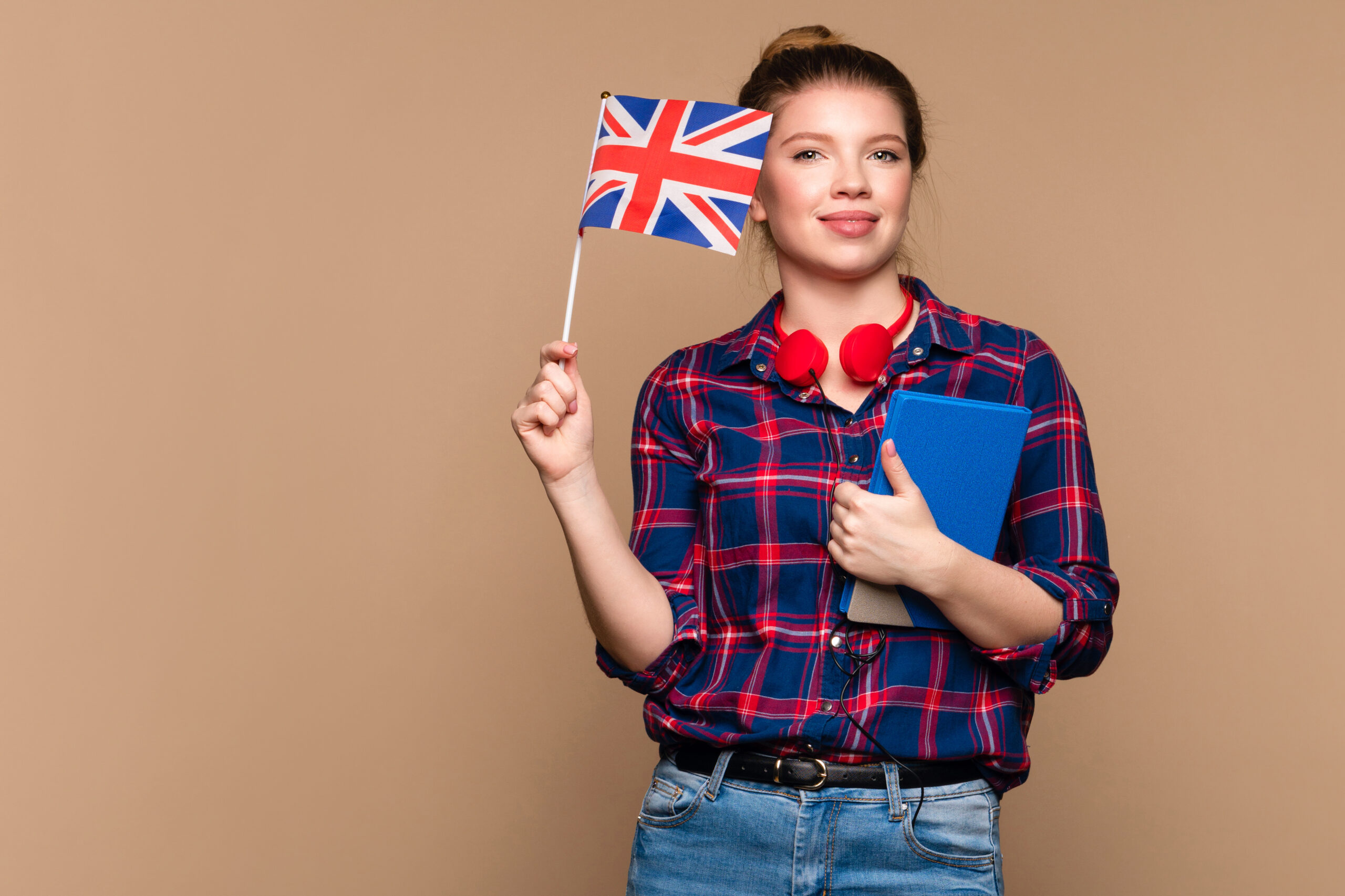 girl holds small UK flag and notebook