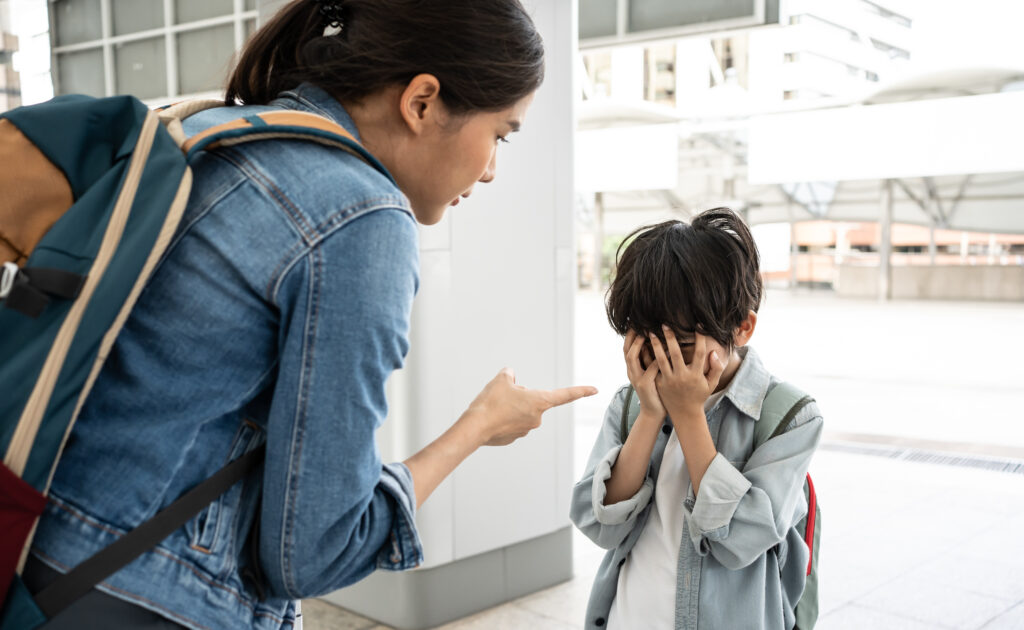 Asian Mother scolds her son while travel A child cries a woman shakes her finger because of the boy bad behavior Rule of conduct boy cover his face and cry