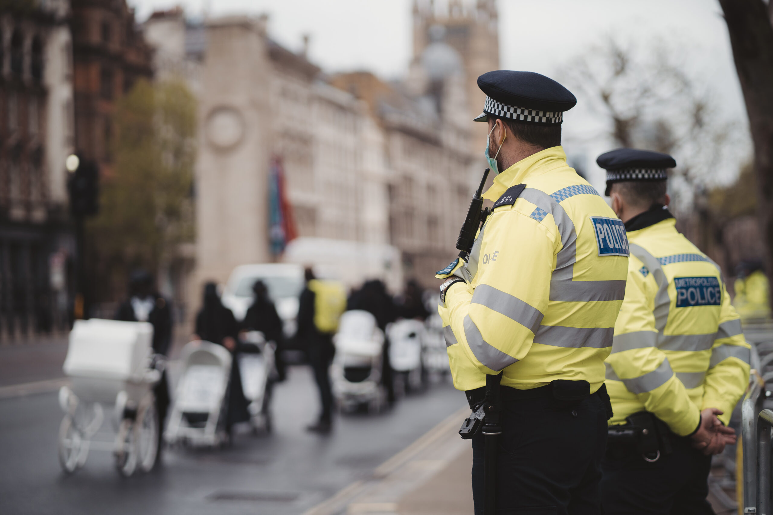 Extinction Rebellion activists marching next to Downing Street with White Baby Prams in front of Police officers