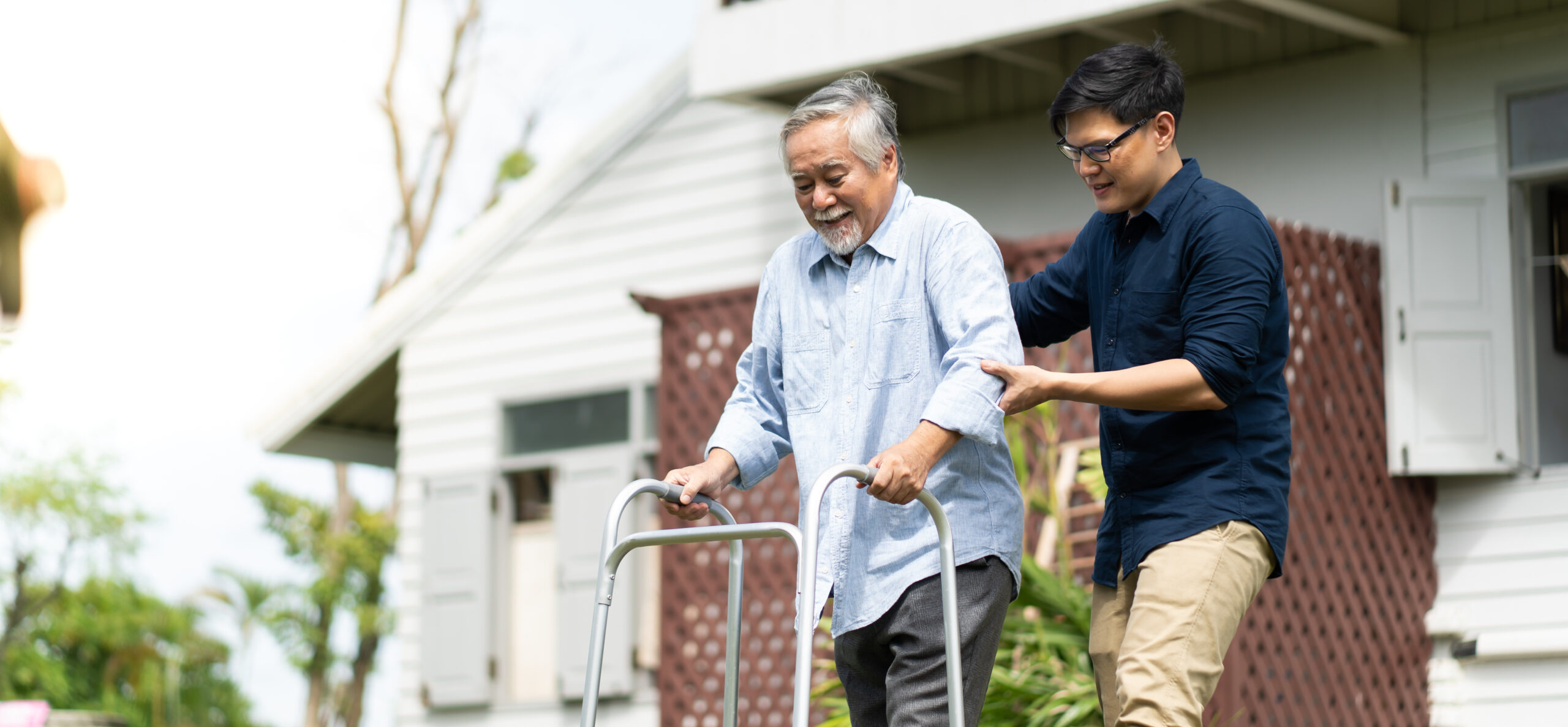 Elderly Asian father and Adult son walking in backyard Positive