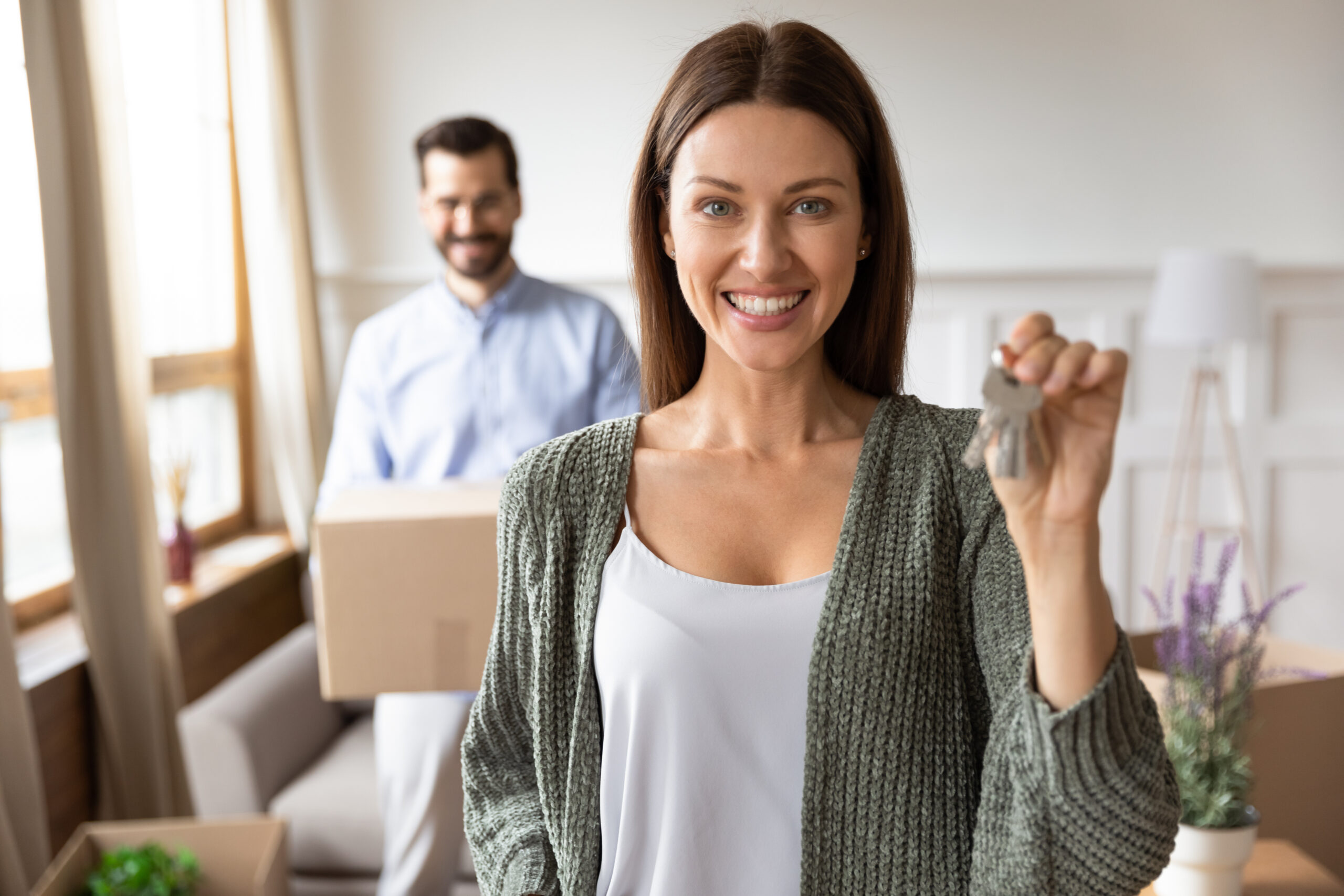 Portrait of smiling wife show house keys relocating
