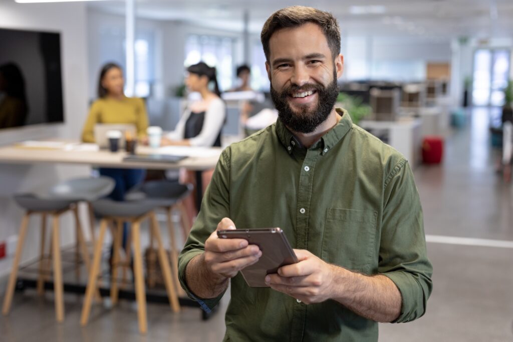 Happy bearded man holding tablet