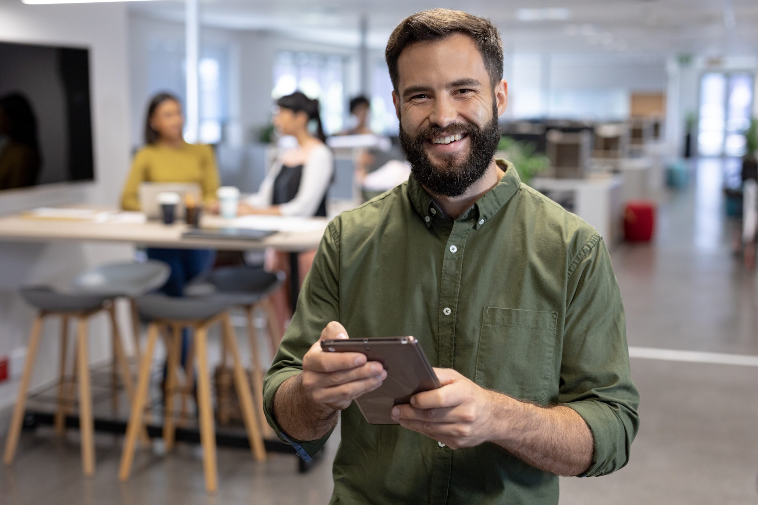 Happy bearded man holding tablet