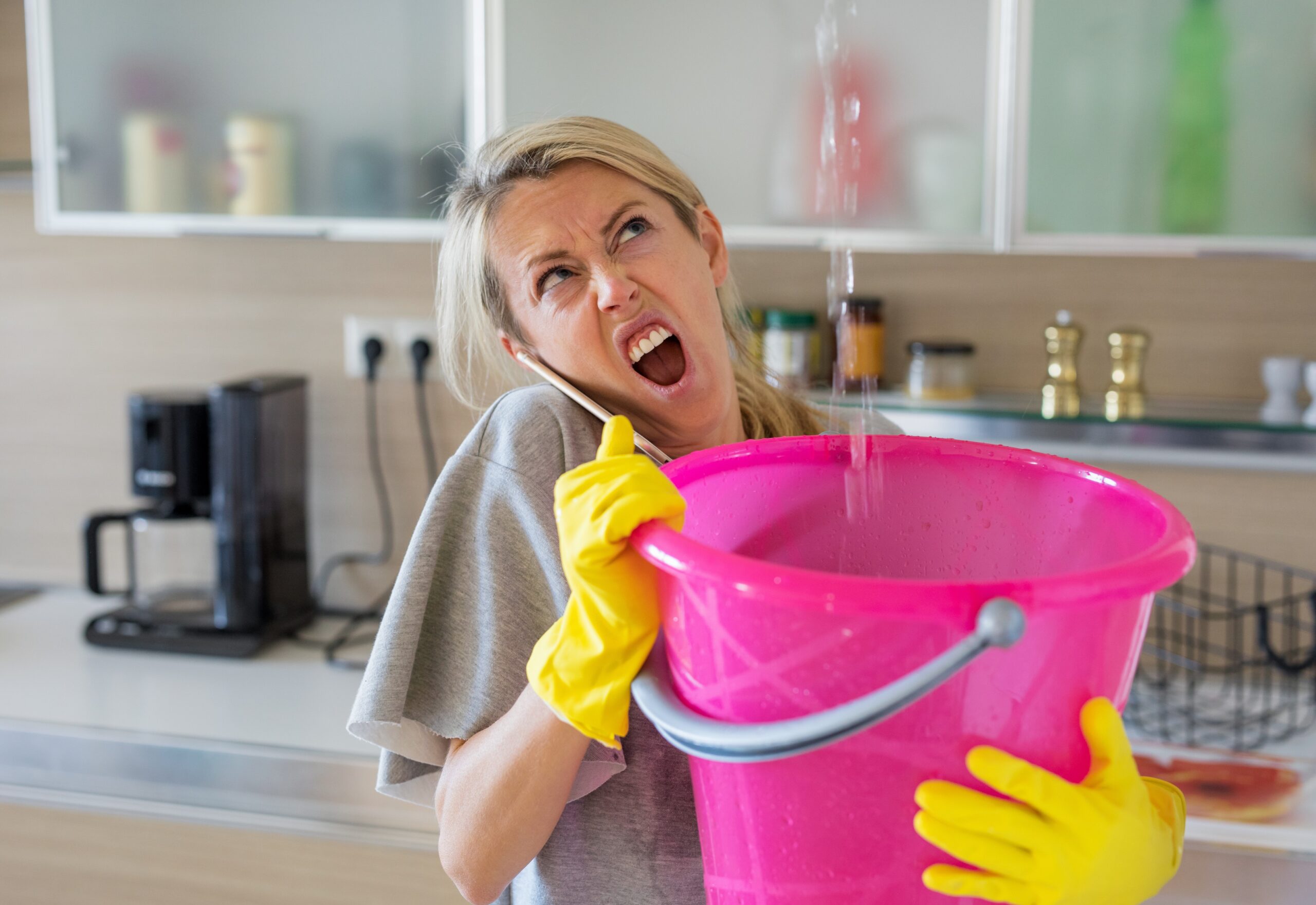 woman holding pink bucket to stop leak
