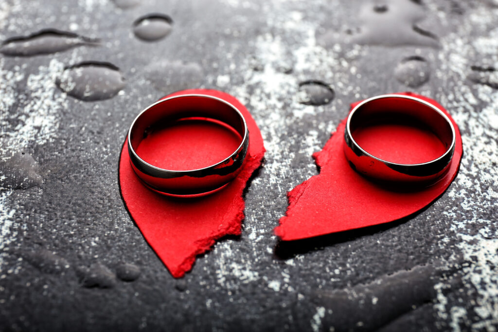 Broken heart and rings on grunge background Concept of divorce