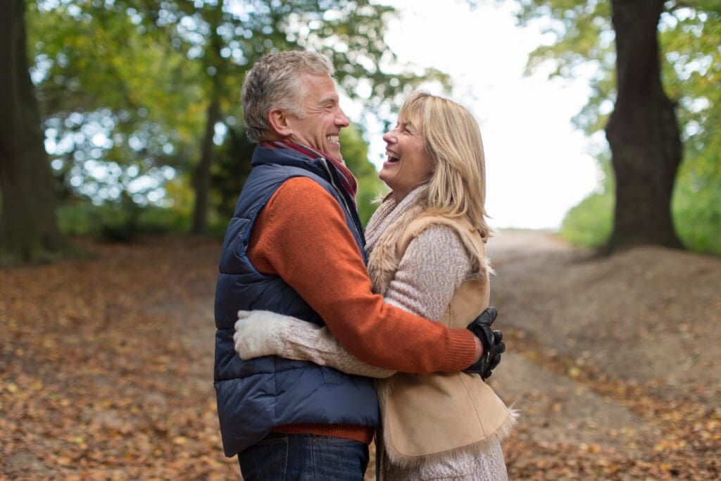 Mature couple embracing in woods
