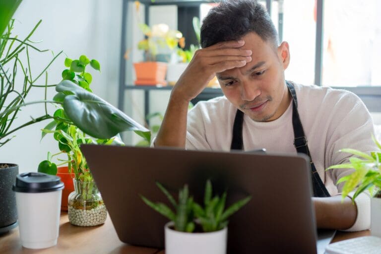 Close up of sad business owner using laptop