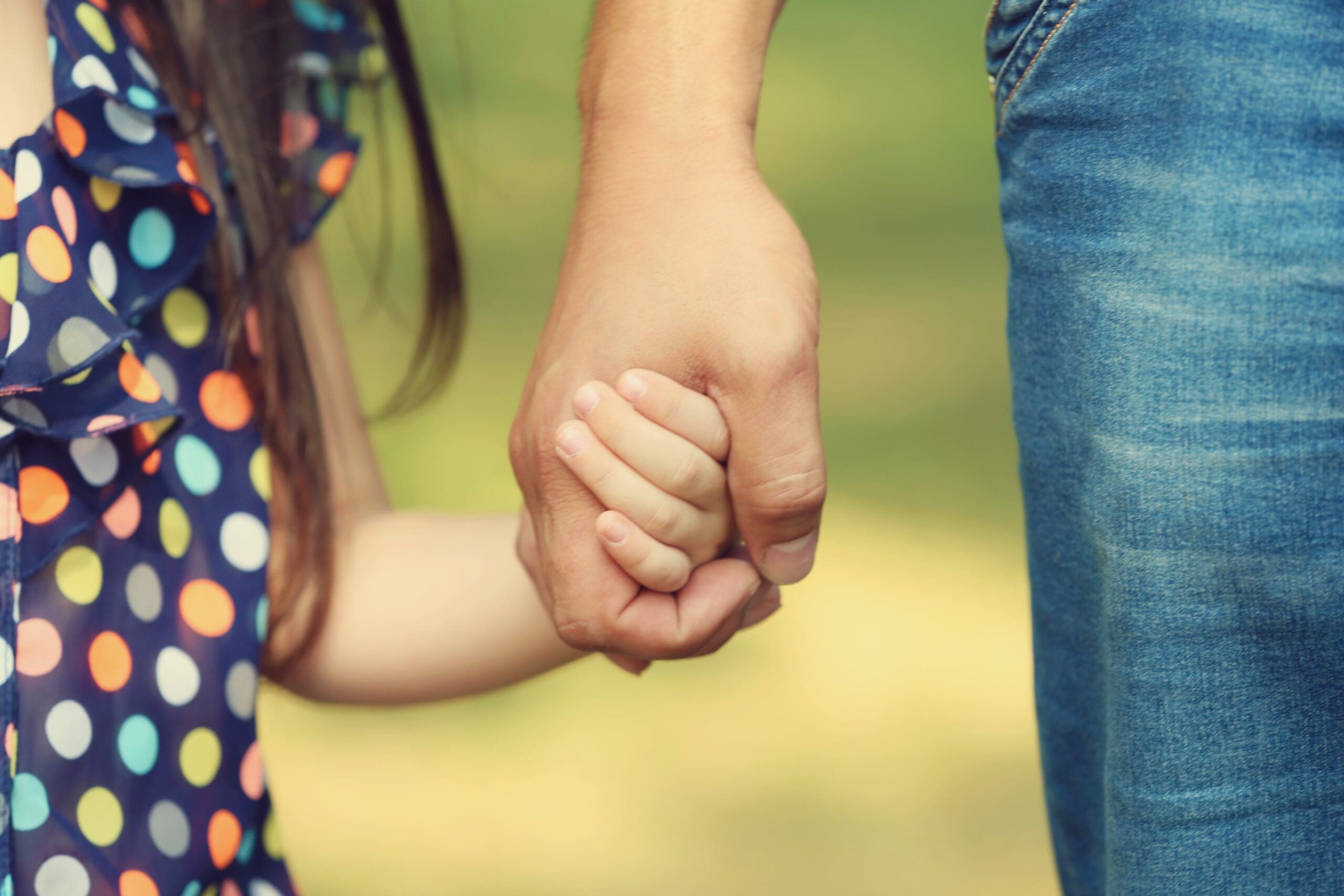 Father's hand lead his child daughter outdoors, trust family concept