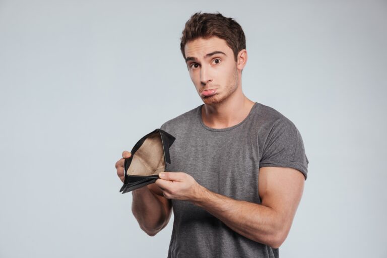 Portrait of an unhappy sad man showing empty wallet